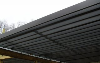 close up of underneath of black pergola being constructed